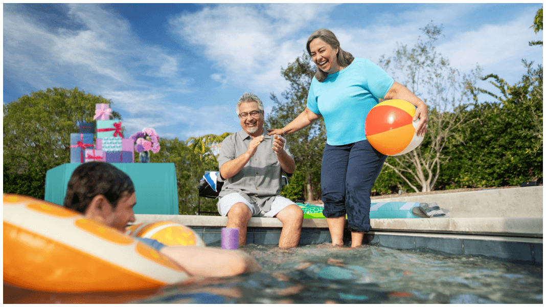 Two men and woman sitting next to the pool.