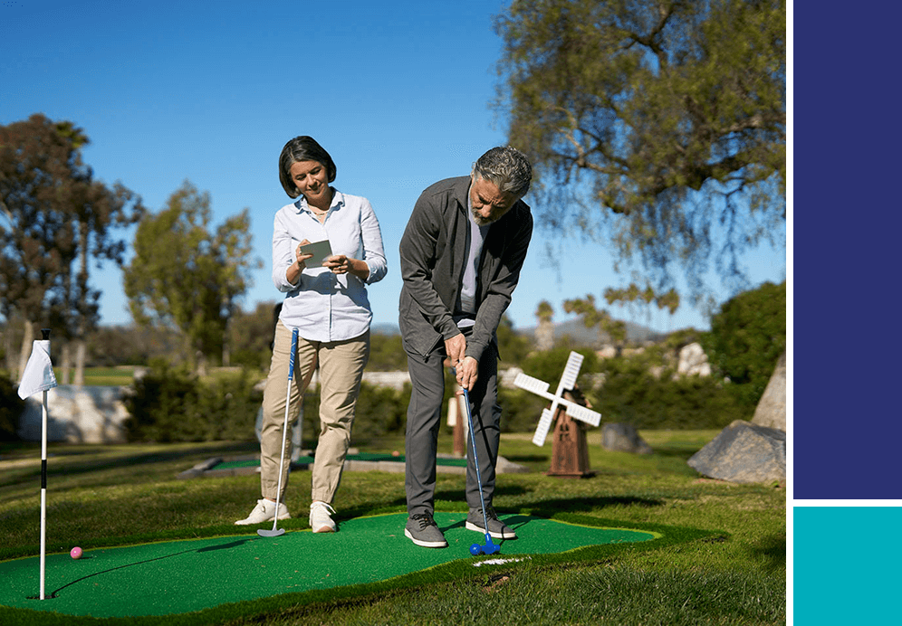 Man and woman playing putt putt golf.