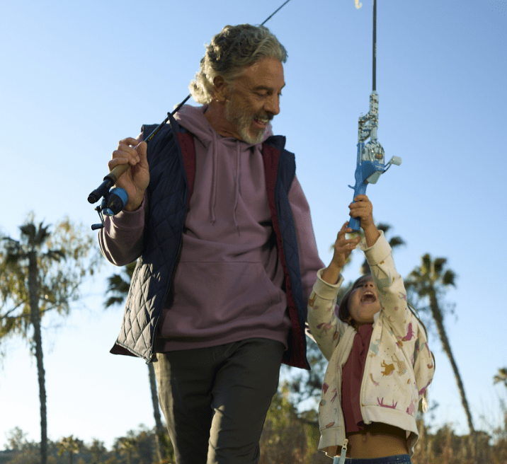 Man and girl holding two fishing poles.