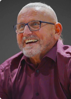 Michael, a real EPKINLY patient, wearing a purple shirt and smiling.