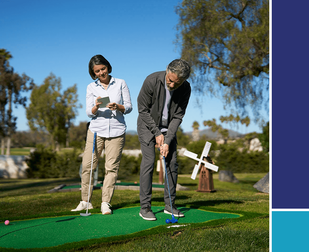 Man and woman playing putt putt golf.