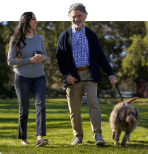 Man and woman walking dog.