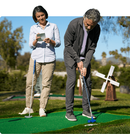 Man and woman playing putt putt golf.