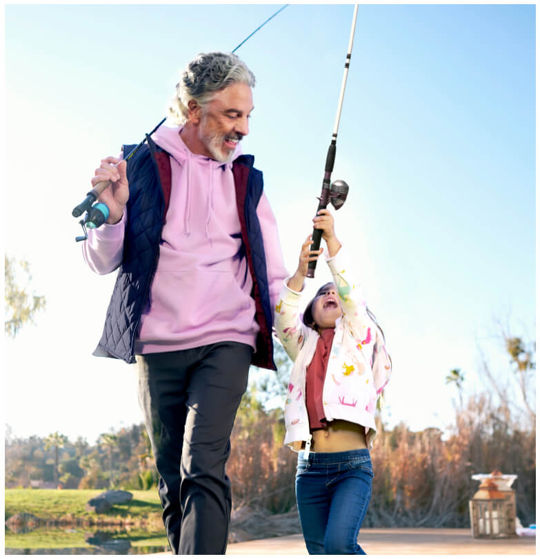 Man and girl walking together with fishing poles.